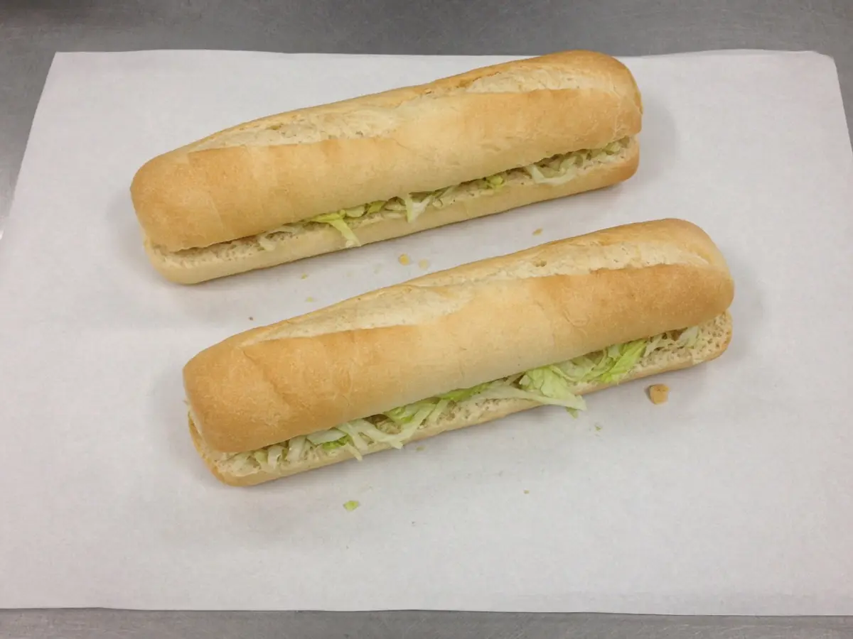 Original food photograph of two footlong subs on deli paper, showing the shape of a buy-one-get-one offer, with no logo.